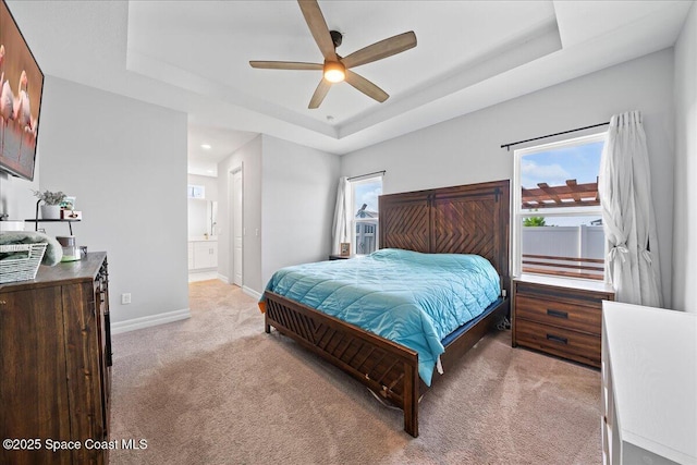 1160 Larkspur St SE, Palm Bay, FL 32909 - bedroom featuring light carpet, a raised ceiling, baseboards, connected bathroom, and ceiling fan