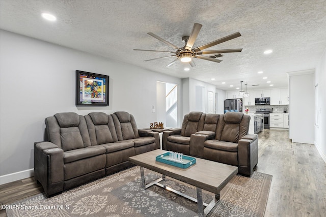 5060 Spinet Dr, Melbourne, FL 32940 - living room featuring a ceiling fan, light wood-type flooring, a textured ceiling, recessed lighting, and baseboards