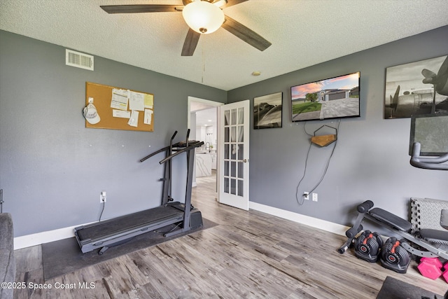 5060 Spinet Dr, Melbourne, FL 32940 - exercise room with wood finished floors, a textured ceiling, baseboards, ceiling fan, and french doors