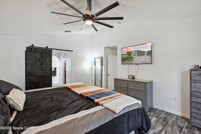 5060 Spinet Dr, Melbourne, FL 32940 - bedroom featuring lofted ceiling, arched walkways, dark wood-type flooring, a textured ceiling, and baseboards