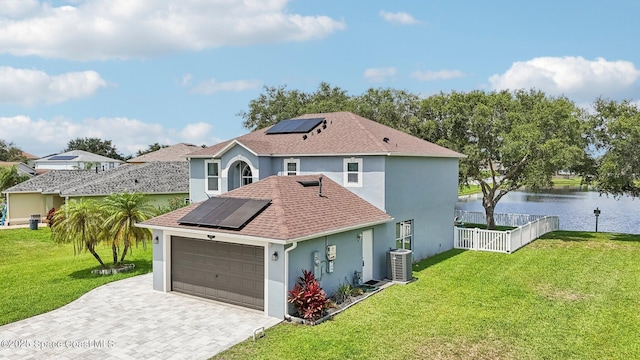 5060 Spinet Dr, Melbourne, FL 32940 - rear view of house with roof mounted solar panels, stucco siding, a water view, and a garage