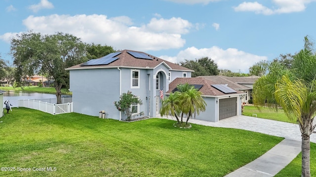 5060 Spinet Dr, Melbourne, FL 32940 - mediterranean / spanish house featuring roof mounted solar panels, stucco siding, a garage, a water view, and decorative driveway