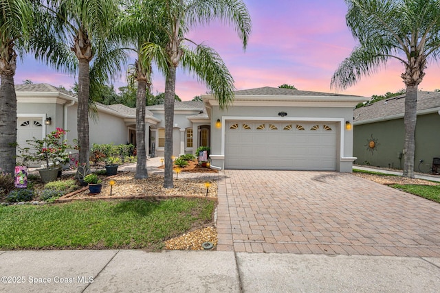 2009 Tullagee Ave, Melbourne, FL 32940 - ranch-style house featuring stucco siding, decorative driveway, and an attached garage