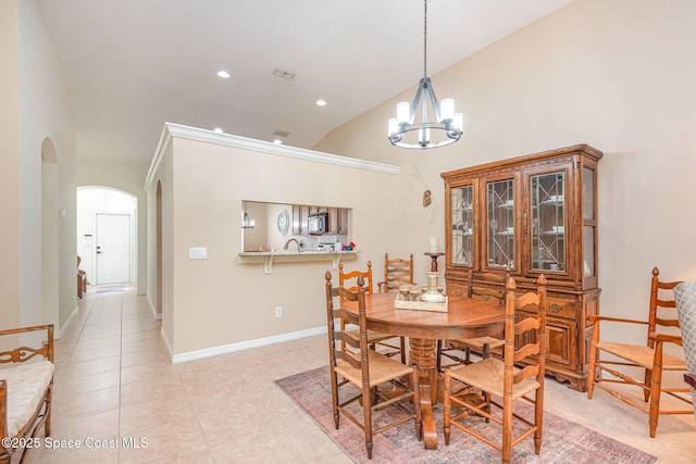 2009 Tullagee Ave, Melbourne, FL 32940 - dining room featuring arched walkways, a chandelier, light tile patterned flooring, baseboards, and high vaulted ceiling