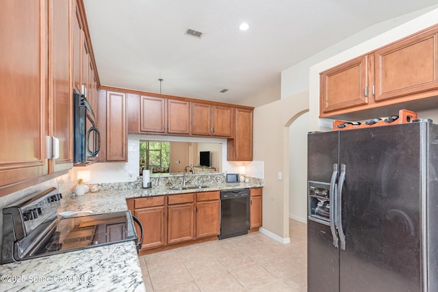 2009 Tullagee Ave, Melbourne, FL 32940 - kitchen with black appliances, a sink, arched walkways, brown cabinets, and light tile patterned flooring