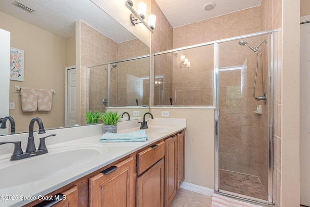 2009 Tullagee Ave, Melbourne, FL 32940 - bathroom with a stall shower, double vanity, tile patterned flooring, and a textured ceiling