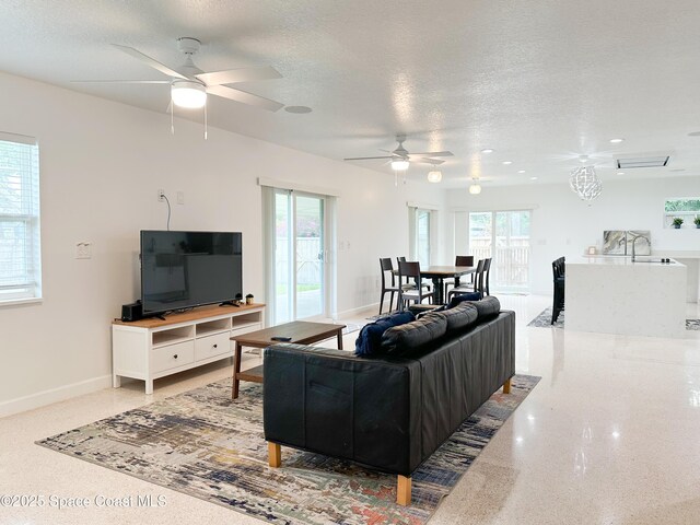 234 Micanopy Ct, Indian Harbour Beach, FL 32937 - living room with ceiling fan, a textured ceiling, dark speckled floor, and baseboards