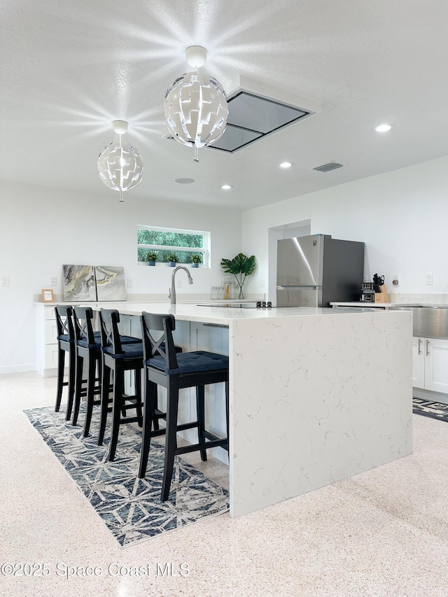 234 Micanopy Ct, Indian Harbour Beach, FL 32937 - kitchen featuring freestanding refrigerator, white cabinets, recessed lighting, a breakfast bar, and a sink