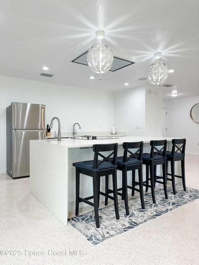 234 Micanopy Ct, Indian Harbour Beach, FL 32937 - kitchen featuring freestanding refrigerator, light countertops, dark aggregate flooring, recessed lighting, and a large island