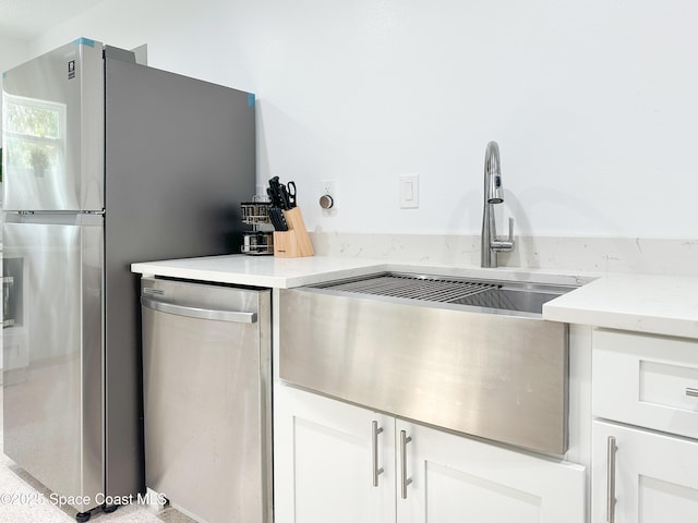234 Micanopy Ct, Indian Harbour Beach, FL 32937 - kitchen featuring stainless steel appliances, a sink, white cabinetry, and light stone counters