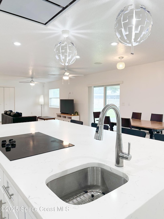 234 Micanopy Ct, Indian Harbour Beach, FL 32937 - kitchen with black electric stovetop, a sink, white cabinetry, open floor plan, and recessed lighting