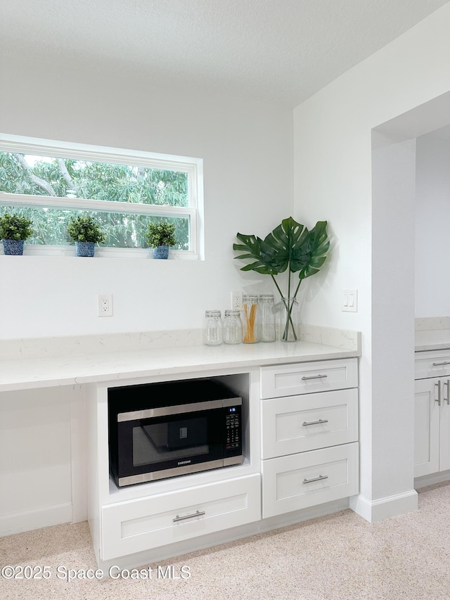 234 Micanopy Ct, Indian Harbour Beach, FL 32937 - detailed view of stainless steel microwave, baseboards, and speckled floor