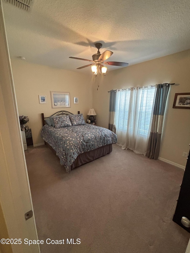 5908 Van Ness Dr, Melbourne, FL 32940 - carpeted bedroom with a textured ceiling, ceiling fan, and baseboards