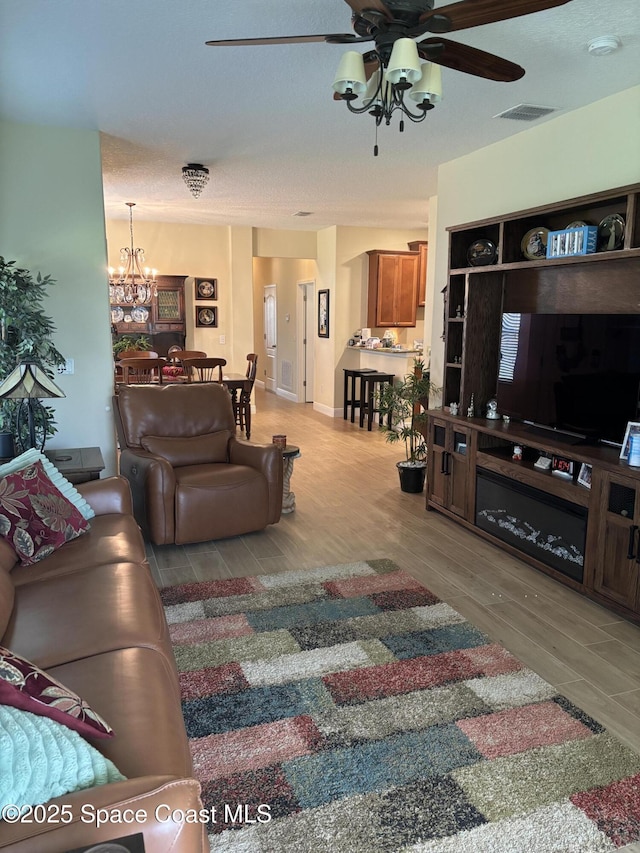 5908 Van Ness Dr, Melbourne, FL 32940 - living area featuring a ceiling fan, wood finished floors, and a chandelier