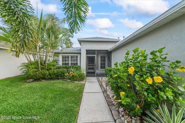 1776 Sawgrass Dr SW, Palm Bay, FL 32908 - entrance to property with stucco siding, a yard, and a shingled roof