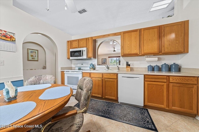 1776 Sawgrass Dr SW, Palm Bay, FL 32908 - kitchen with white appliances, ceiling fan, light countertops, and arched walkways
