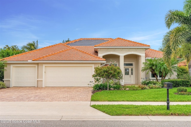 3360 Thurloe Dr, Rockledge, FL 32955 - mediterranean / spanish-style home featuring decorative driveway, stucco siding, a tile roof, and an attached garage