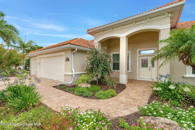 3360 Thurloe Dr, Rockledge, FL 32955 - mediterranean / spanish house featuring a tiled roof, stucco siding, a garage, and driveway