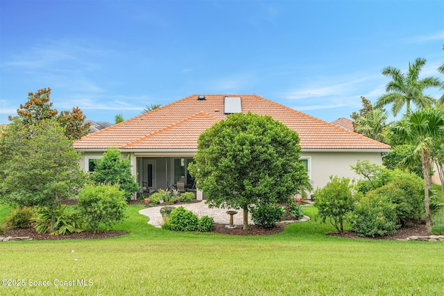 3360 Thurloe Dr, Rockledge, FL 32955 - rear view of property with a tiled roof, a lawn, and stucco siding