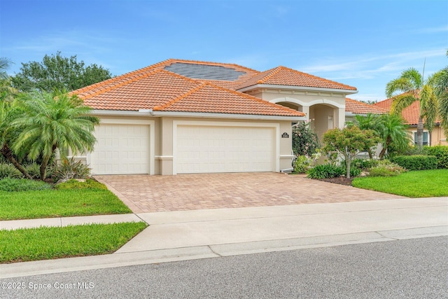 3360 Thurloe Dr, Rockledge, FL 32955 - mediterranean / spanish-style home with decorative driveway, a garage, stucco siding, and a tile roof
