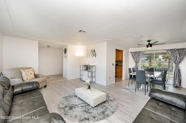 1505 W Central Ave, Merritt Island, FL 32952 - living room with a textured ceiling, a ceiling fan, light wood-type flooring, and baseboards
