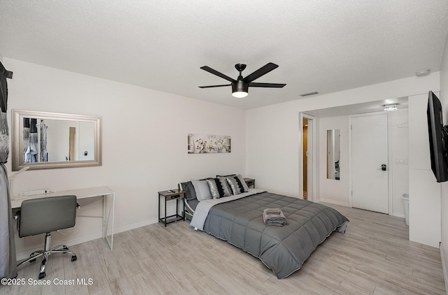 1505 W Central Ave, Merritt Island, FL 32952 - bedroom with light wood-style floors, a desk, baseboards, a ceiling fan, and a textured ceiling