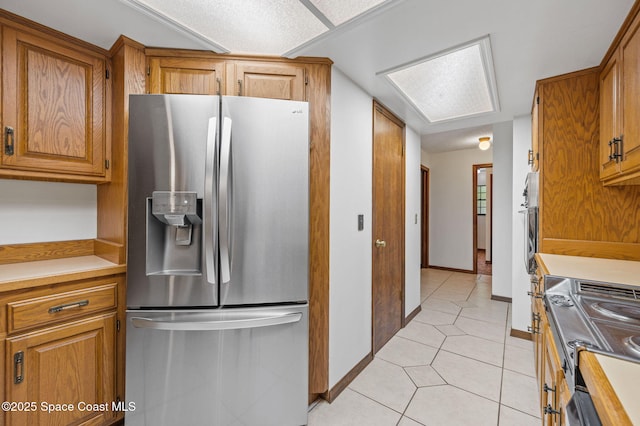 7001 Windover Way, Titusville, FL 32780 - kitchen with appliances with stainless steel finishes, light tile patterned floors, brown cabinetry, and light countertops