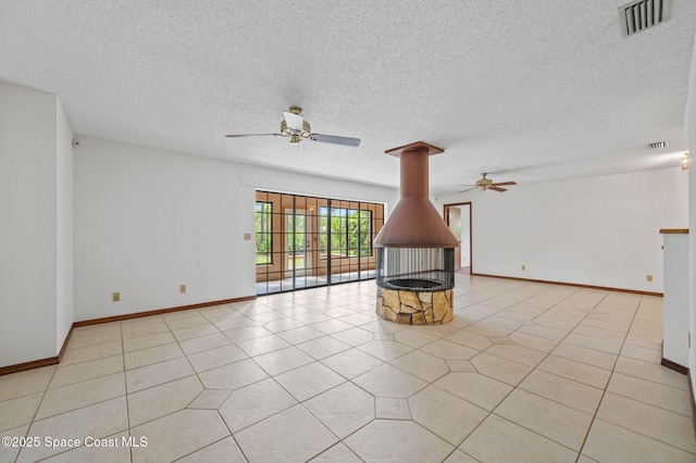 7001 Windover Way, Titusville, FL 32780 - unfurnished living room with ceiling fan, a textured ceiling, light tile patterned floors, and a wood stove