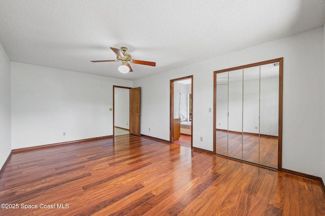 7001 Windover Way, Titusville, FL 32780 - unfurnished bedroom featuring wood finished floors, a textured ceiling, ensuite bathroom, ceiling fan, and a closet