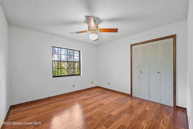 7001 Windover Way, Titusville, FL 32780 - unfurnished bedroom with wood finished floors, a closet, a textured ceiling, and ceiling fan