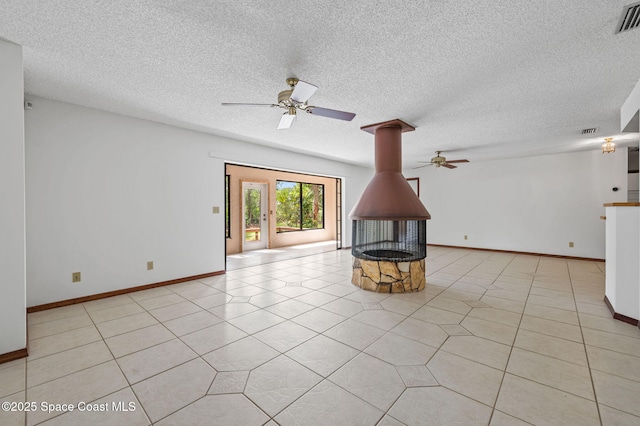 7001 Windover Way, Titusville, FL 32780 - unfurnished living room featuring ceiling fan, a wood stove, a textured ceiling, and light tile patterned floors