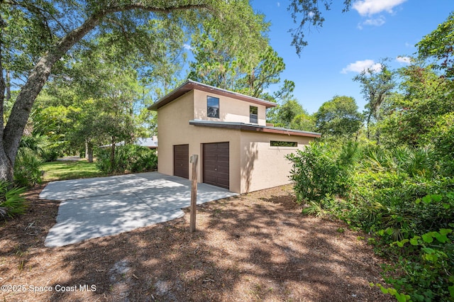 7001 Windover Way, Titusville, FL 32780 - view of home's exterior featuring a garage, stucco siding, and driveway