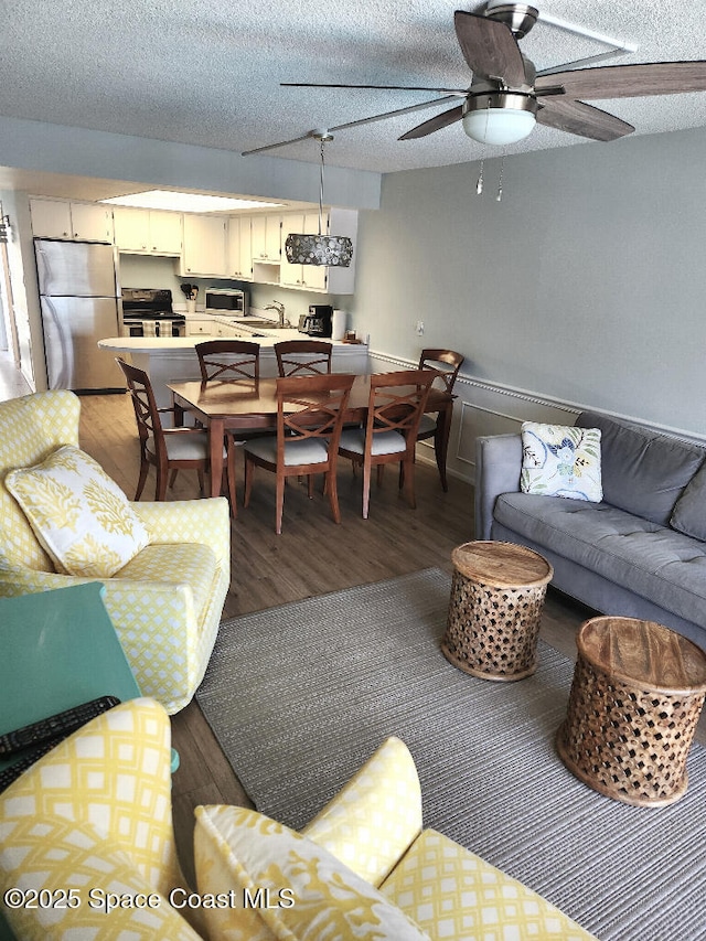 504 Fillmore Ave Unit B-8, Cape Canaveral, FL 32920 - living room featuring light wood-style flooring, ceiling fan, and a textured ceiling