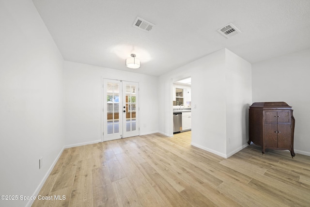 2036 Hogan Dr, Melbourne, FL 32935 - unfurnished living room with light wood-style flooring, french doors, baseboards, and a sink