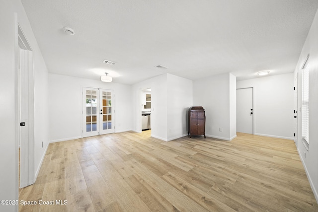2036 Hogan Dr, Melbourne, FL 32935 - unfurnished living room with light wood-type flooring, french doors, and baseboards