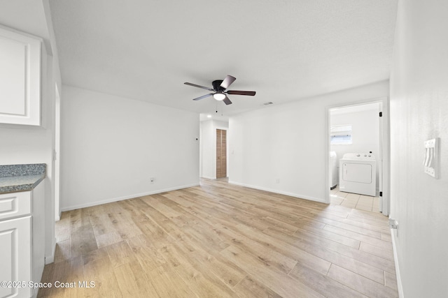 2036 Hogan Dr, Melbourne, FL 32935 - unfurnished living room featuring separate washer and dryer, light wood-style floors, ceiling fan, and baseboards