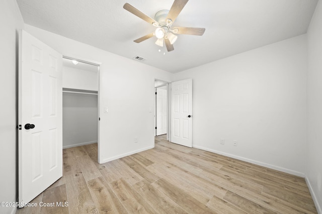 2036 Hogan Dr, Melbourne, FL 32935 - unfurnished bedroom with light wood finished floors, baseboards, a spacious closet, ceiling fan, and a closet