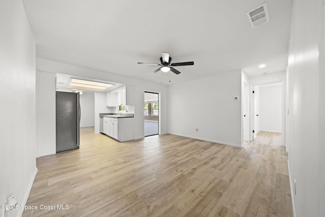 2036 Hogan Dr, Melbourne, FL 32935 - unfurnished living room with ceiling fan, light wood finished floors, a sink, baseboards, and recessed lighting