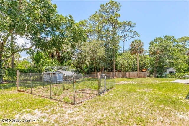 439 Blue Heron Rd, Melbourne Village, FL 32904 - view of yard with a garden, view of wooded area, and an outdoor structure