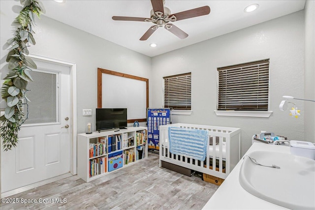 439 Blue Heron Rd, Melbourne Village, FL 32904 - bedroom featuring wood finished floors, recessed lighting, ceiling fan, and a crib