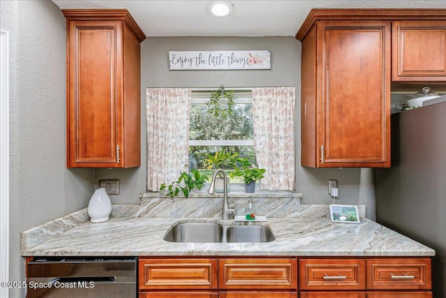 439 Blue Heron Rd, Melbourne Village, FL 32904 - kitchen with dishwasher, light stone countertops, brown cabinets, and a textured wall