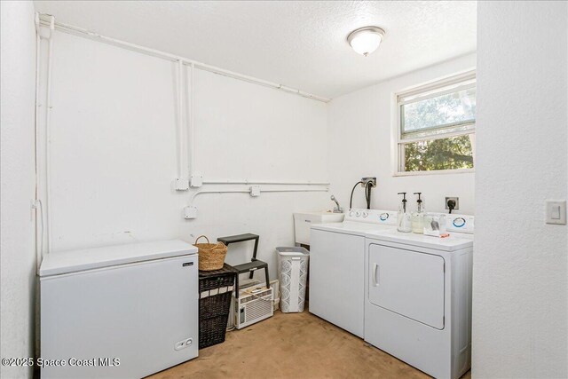 439 Blue Heron Rd, Melbourne Village, FL 32904 - laundry room featuring washing machine and clothes dryer, light colored carpet, and a textured ceiling