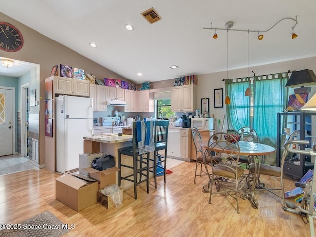 3625 2nd Ln, Vero Beach, FL 32968 - kitchen with white appliances, light wood-style floors, under cabinet range hood, light countertops, and a center island