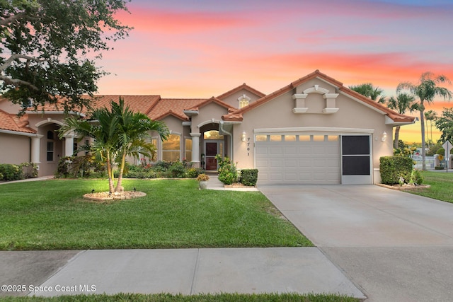 7701 Candlewick Dr, Melbourne, FL 32940 - mediterranean / spanish home with a garage, concrete driveway, stucco siding, a yard, and a tile roof