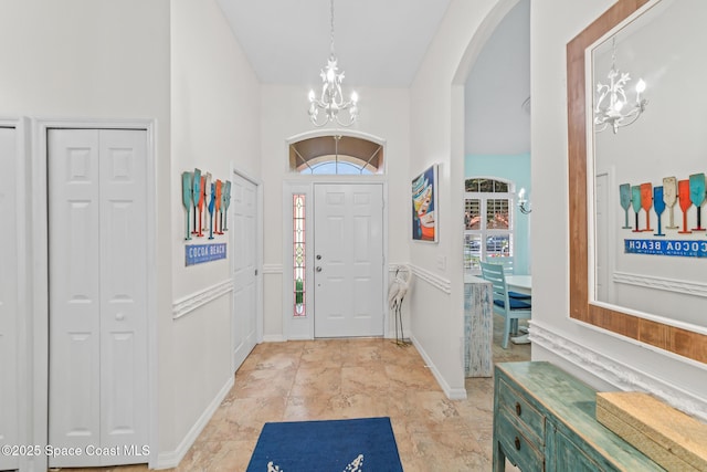 7701 Candlewick Dr, Melbourne, FL 32940 - foyer featuring a chandelier, arched walkways, baseboards, and a high ceiling