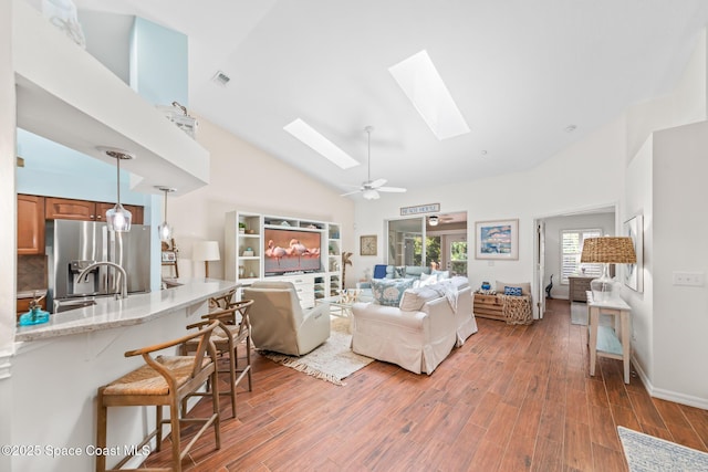 7701 Candlewick Dr, Melbourne, FL 32940 - living room with a skylight, high vaulted ceiling, light wood-type flooring, and a ceiling fan