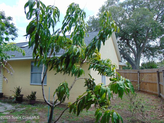 636 Fishtail Palm Blvd, Melbourne, FL 32901 - view of side of home featuring stucco siding and roof with shingles