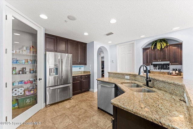 4125 W End Rd Unit 405, Cocoa Beach, FL 32931 - kitchen featuring appliances with stainless steel finishes, a sink, arched walkways, dark brown cabinetry, and recessed lighting