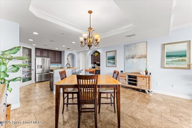 4125 W End Rd Unit 405, Cocoa Beach, FL 32931 - dining space with arched walkways, a chandelier, baseboards, recessed lighting, and stone finish floors
