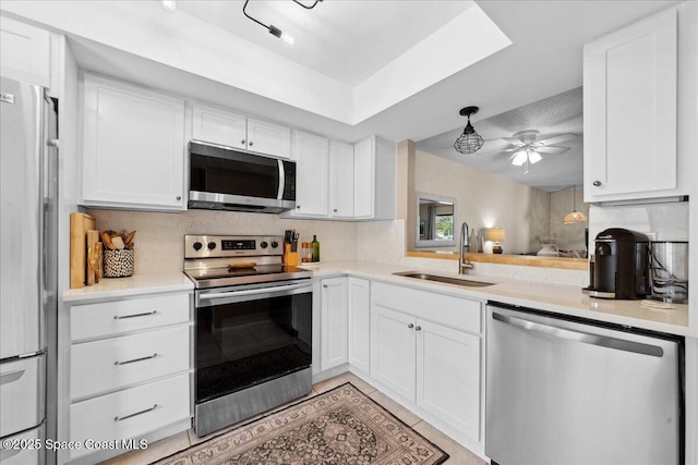 149 Kristi Dr, Indian Harbour Beach, FL 32937 - kitchen featuring stainless steel appliances, a sink, ceiling fan, and white cabinets